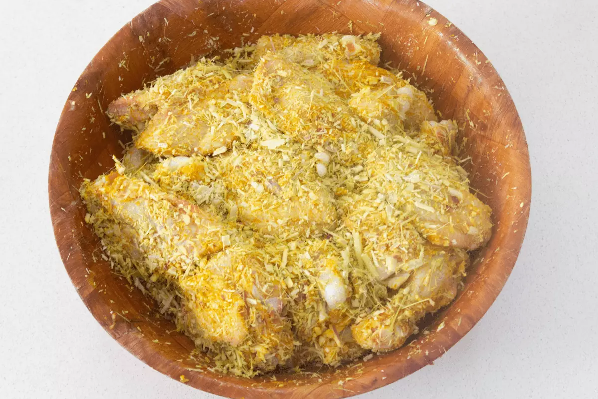 Chicken wings and lemongrass fibers in a bowl.